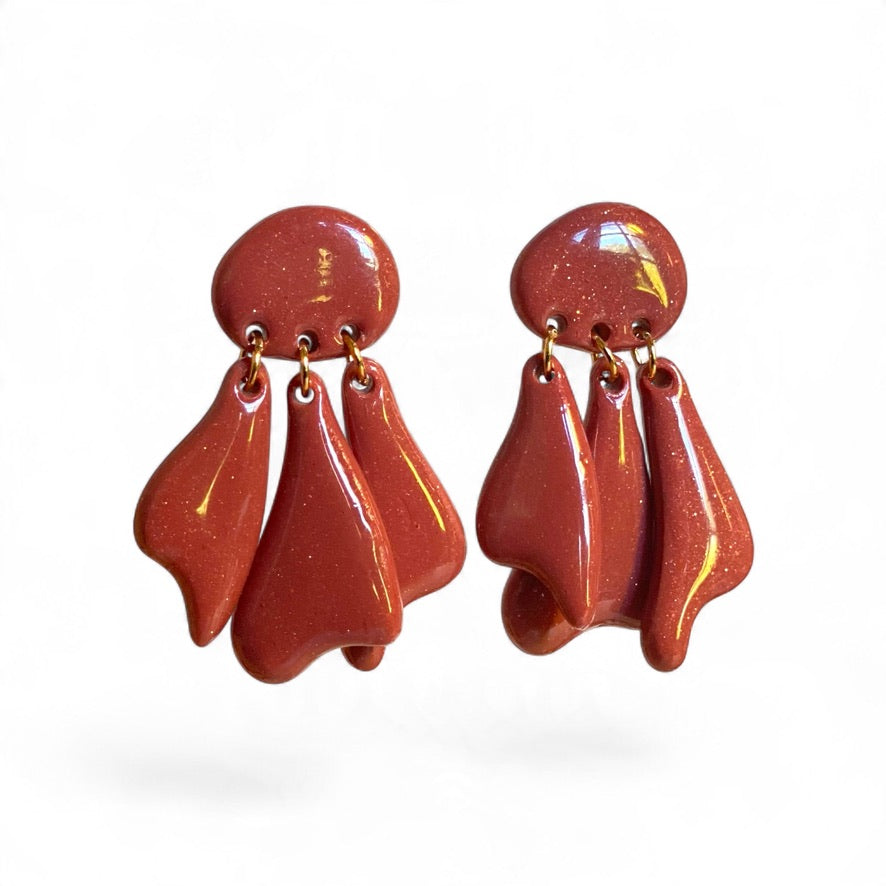 Modèle Médusa bois de rose, boucles d'oreilles artisanales aux pampilles articulées, silhouette fluide et inspiration marine.