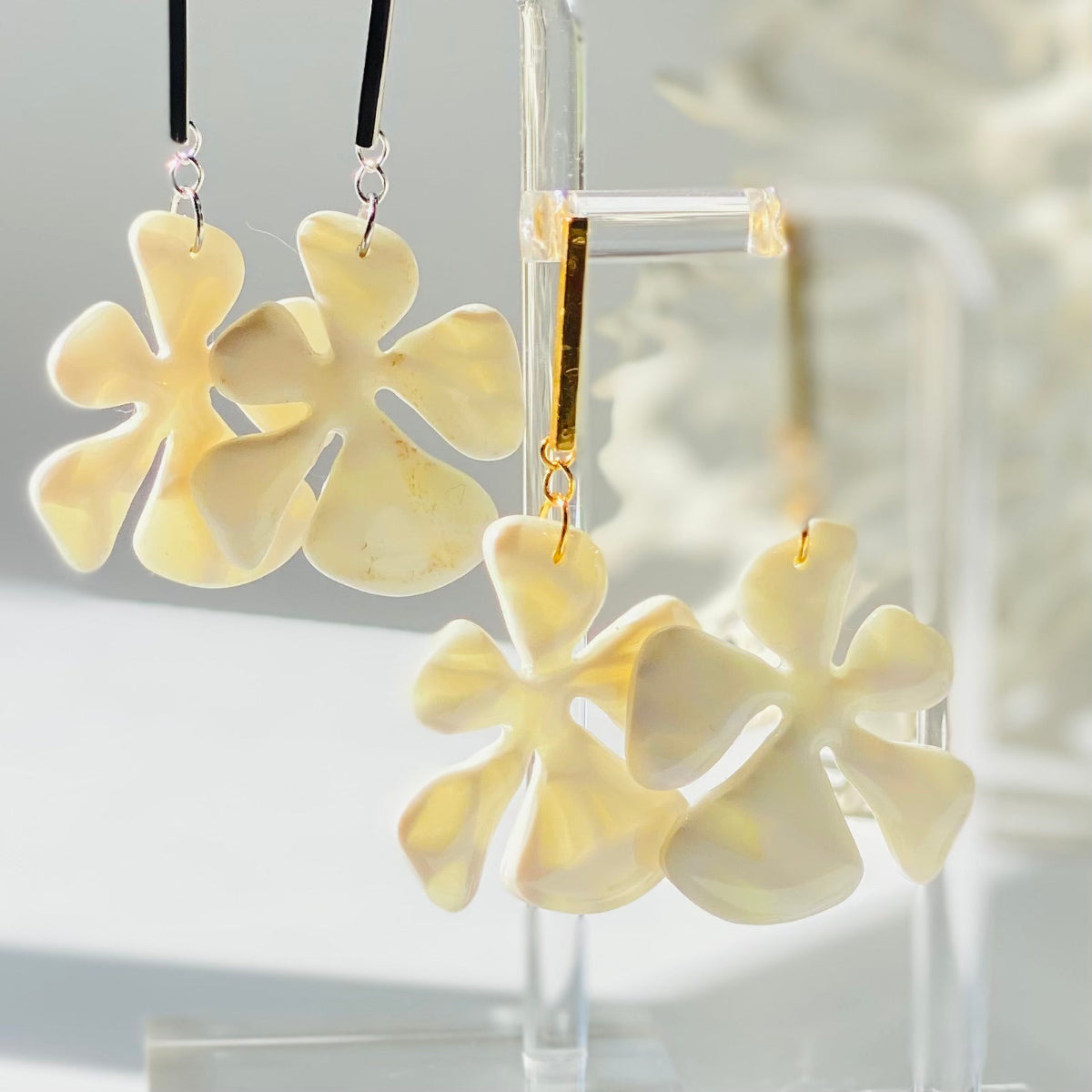 Boucles d'oreilles Balaia blanche et jaune pâle translucide en pâte polymère, vue dans la lumière