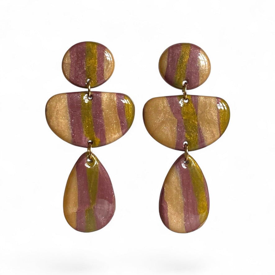 Variante pourpre, champagne et bronze du modèle LOUMA, boucles d’oreilles géométriques pendantes en pâte polymère faites main, aux nuances métallisées.